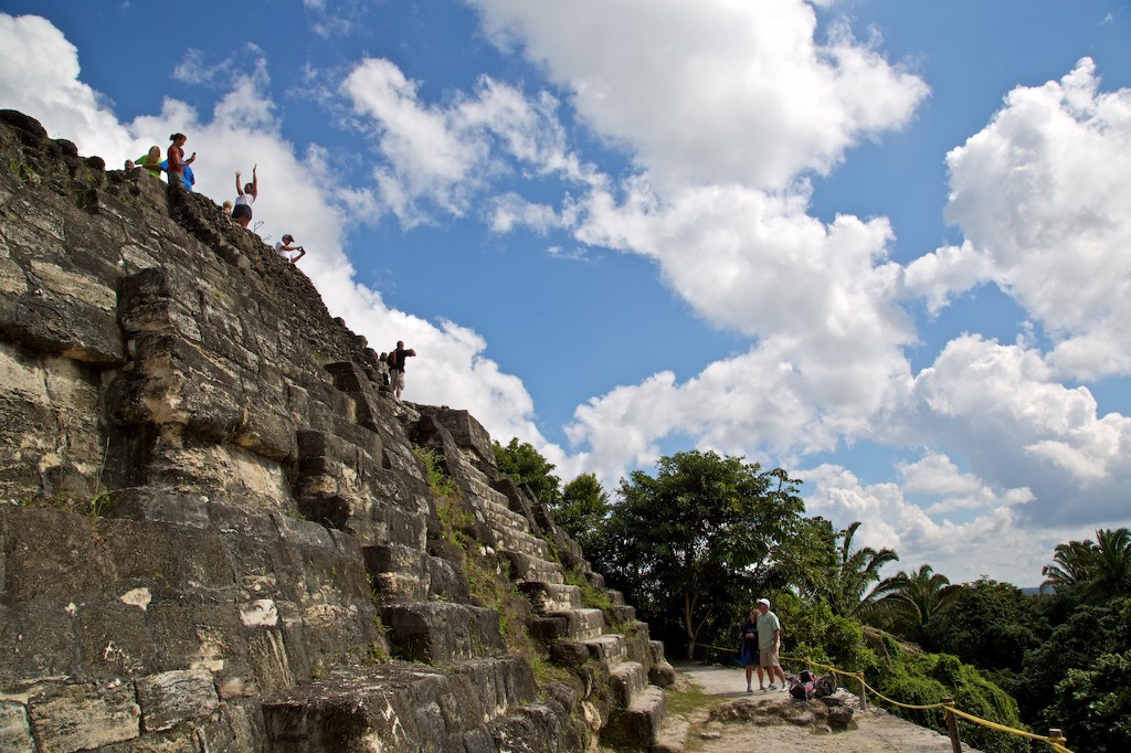 Central and South American Ruins Image: A group of travellers celebrates having reached the top of the temple. Whilst a couple admires them, and considers making the walk themselves.