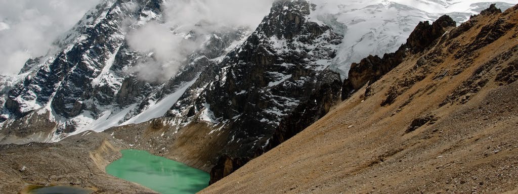 So close, and yet, still more trekking until we actually reach it! Best Hikes In Peru Image: The turquoise pool of the hot spring sits is secluded in the mountain's landscape.
