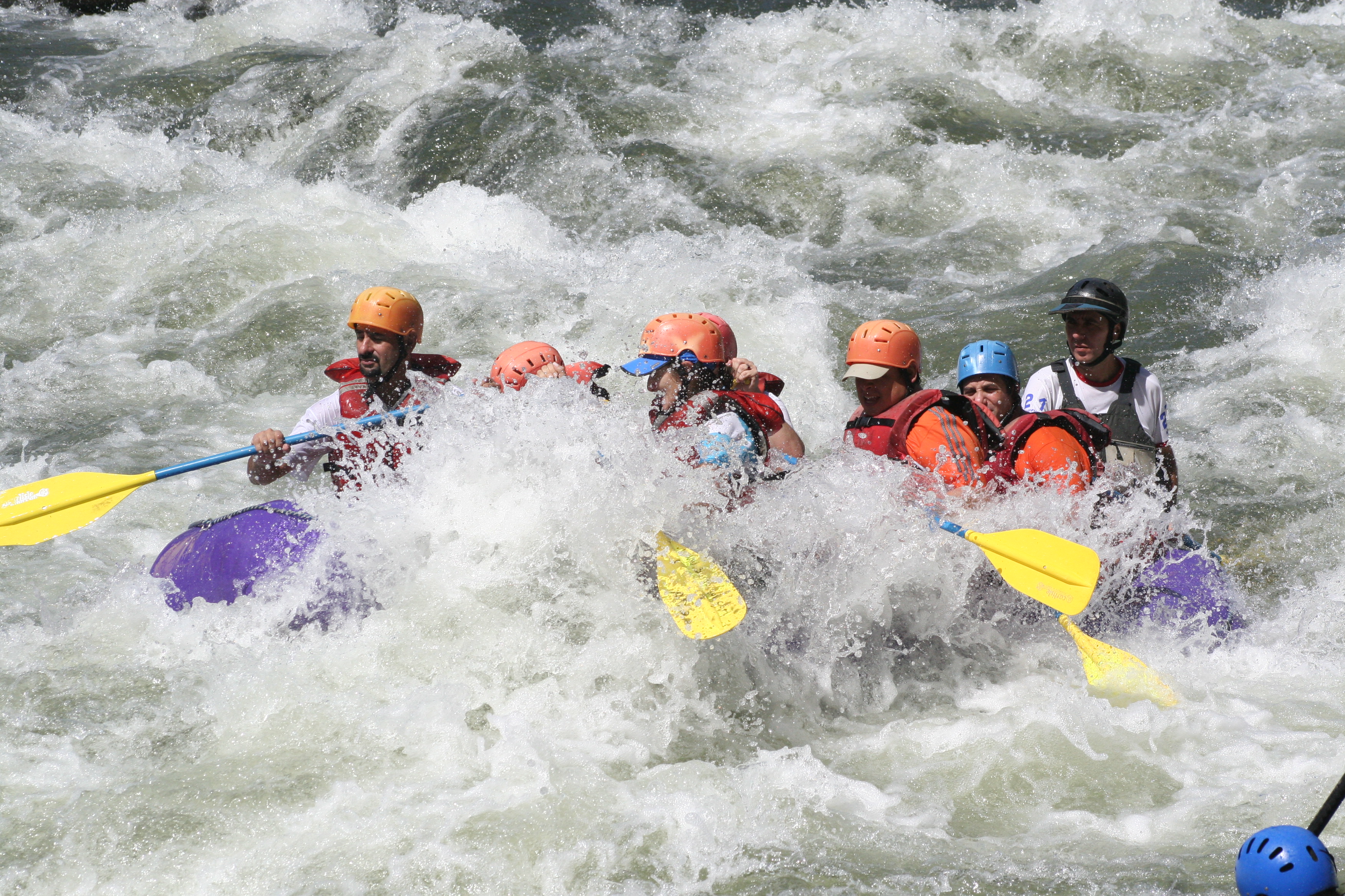 Costa Rica Rafting Image: Sarapiqui River. A group of rafters is getting soaked by intense rapids.
