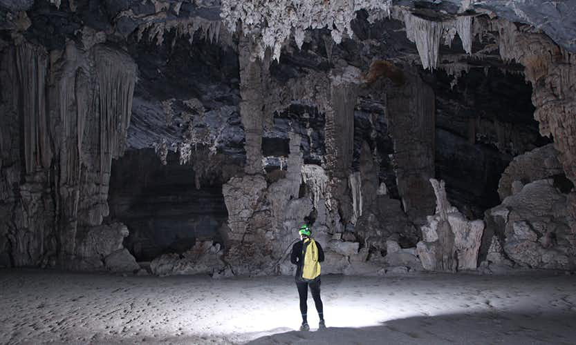 The natural world is incredible, both above ground and below. Caving in Vietnam Image: An adventurer observes the stalactites and other formations of the Tu Lan Cave System.