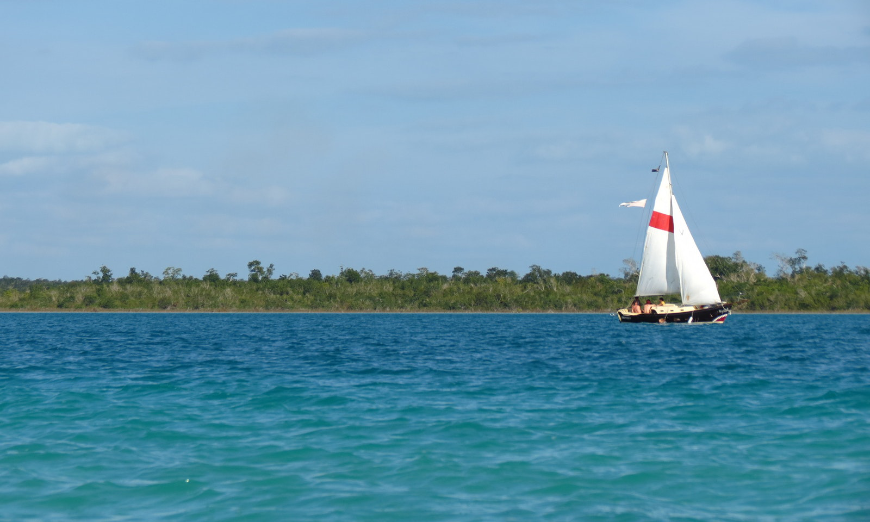 Sailing and diving? It's a 2-in-1 adventure! Diving In Belize Image: A sailboat is in the midst of Bacalar Chico Marine Reserve.