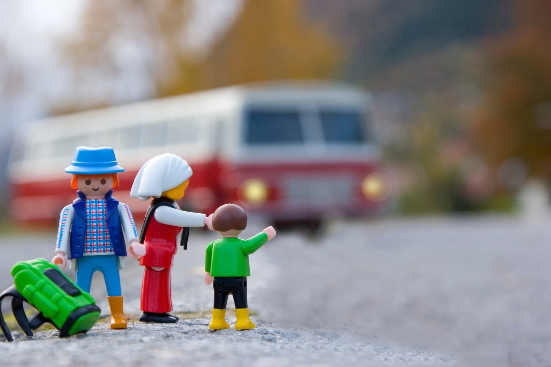 Family Adventure Image: A "family" of three toys waits for their toy transportation to pick them up as they hit the road.