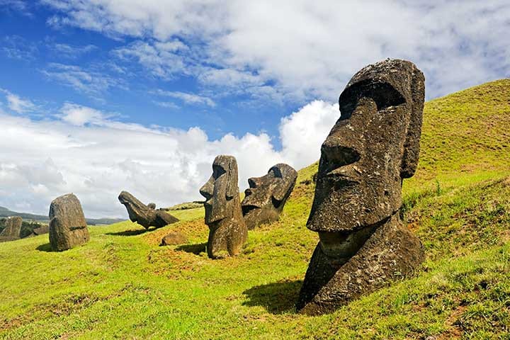 Destinations Worth Dreaming Image: Five moai are visible: three are upright; one is tilted forward, and another is tilted back.