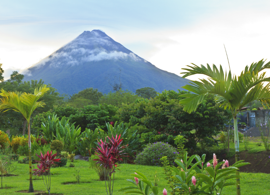 Make-A-Wish Costa Rica Image: Arenal Volcano is graced with low-langing mist; in the foreground is a lush landscape. 