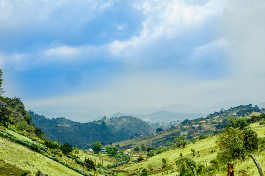 Stop to appreciate the simple, yet overwhelming, beauty of the landscape. Mayans of Guatemala Image: A landscape of rolling green hills, mountains, and clouds.