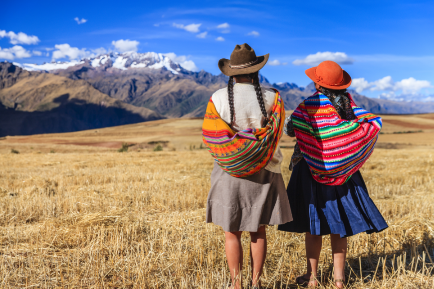 Peru or Ecuador Image: Two women in skirts, colorful wraps, and hats take in the Sacred Valley.