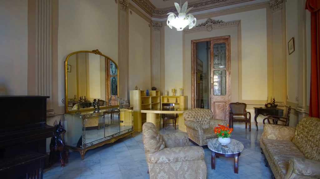 Legally Travel To Cuba Image: An interior view of Casa Prado Colonial shows a nicely decorated sitting room, intended to pull together the home