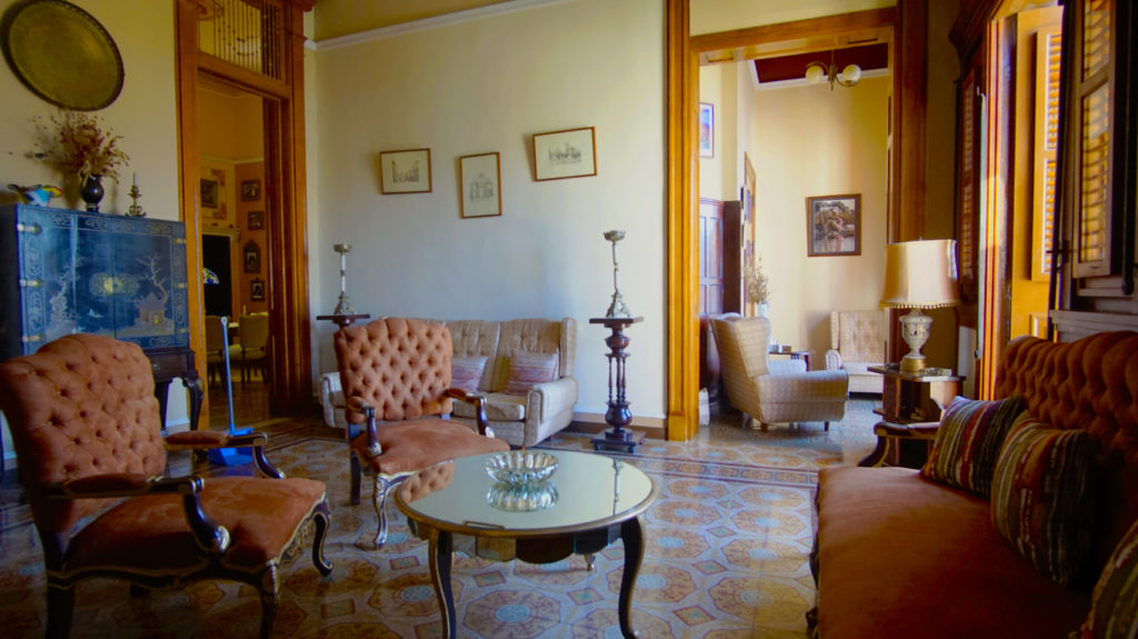 Legally Travel To Cuba Image: A salon/drawing room in the casa particular Hostal del Angel houses sofas, chairs, tables, and other furniture.