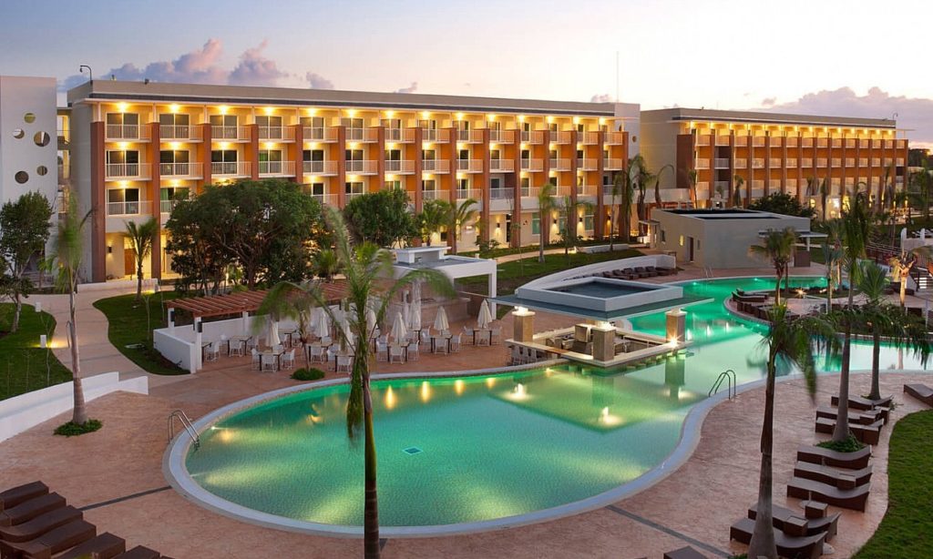 Legally Travel To Cuba Image: Shot of the beautiful and well-lit swimming pool of a luxury resort in Cuba.