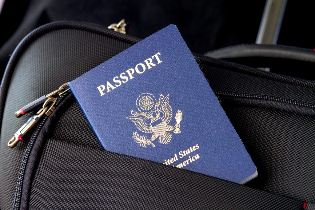 Legally Travel To Cuba Image: A navy blue United States passport peeks out of the front pocket of black luggage.