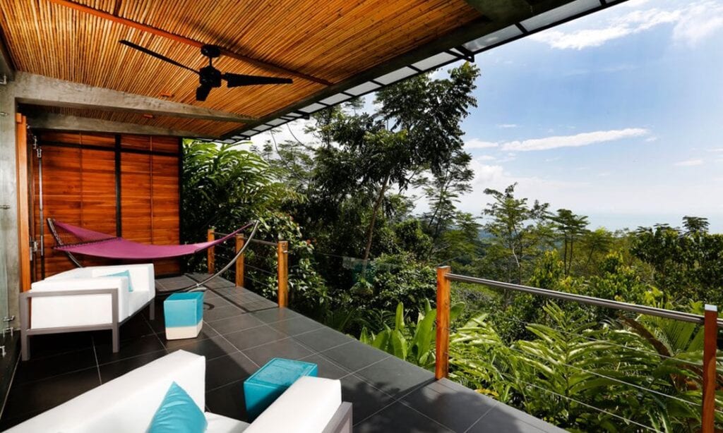 Unique Honeymoon Image: View from a private terrace complete with chairs, ottomans, and a hammock looking out onto a rainforest.