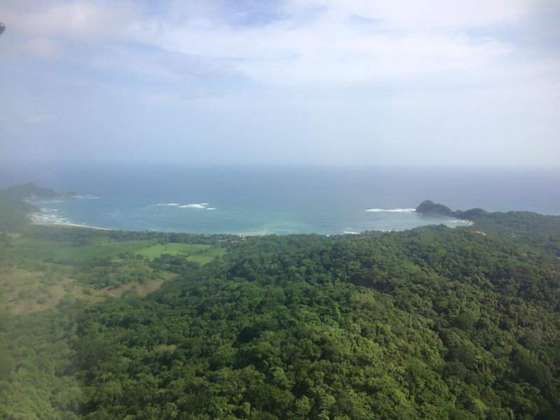 Forested hills running down to the bay at Garza, seen from above