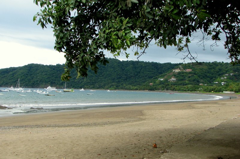 The curve of Playas del Coco beach, with boats anchored in the bay