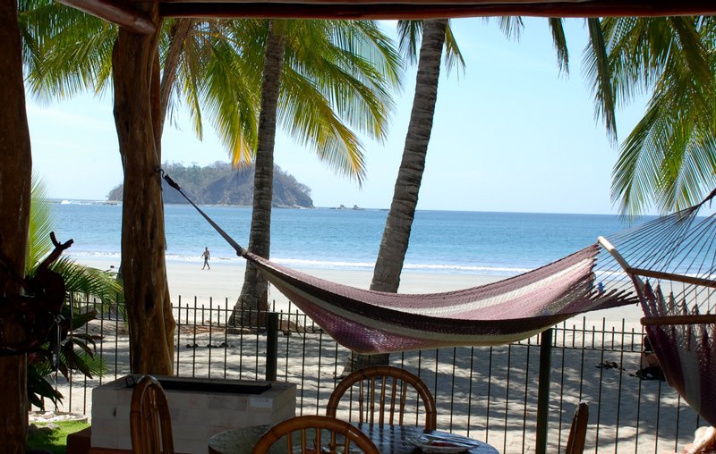 A hammock under the palms looking out over Sámara bay and Isla Chora