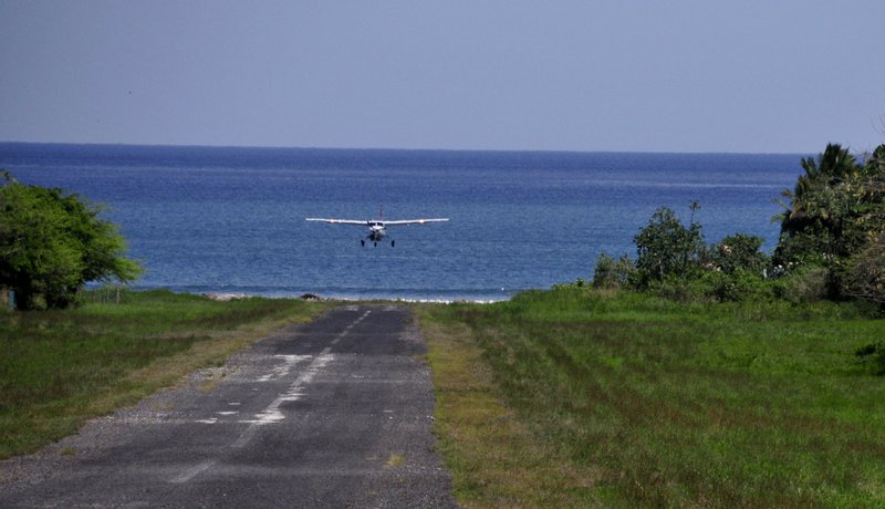 A small plane coming in to land on the Tambor airstrip by the sea